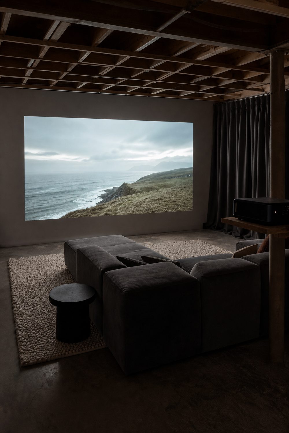 Basement projector lounge with an image projected on a white wall, a modular sectional, thick rug and blackout curtains