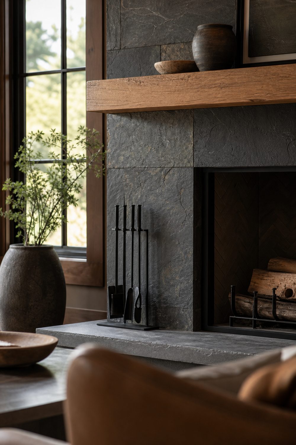 Earthy fireplace surround in natural charcoal slate tile with cleft texture beside a white oak mantel and black steel accents