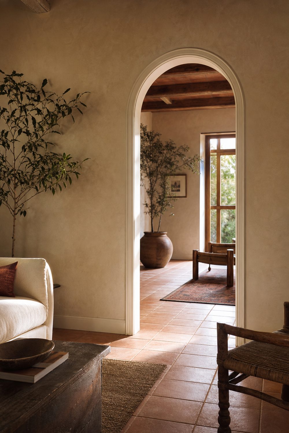 Arched doorway with white casing following the curve continuously in a Mediterranean room with terracotta tile floors