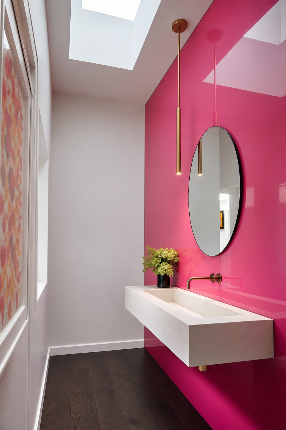 Powder room with one saturated hot pink high gloss lacquer wall, floating white stone sink and a slim gold pendant beside the mirror