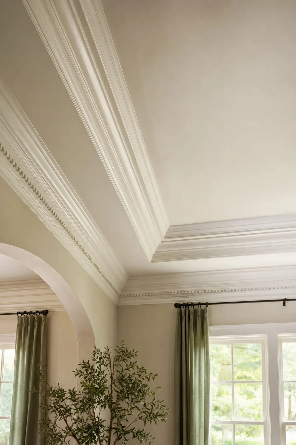 Close view of a tray ceiling edge with layered crown molding, cove and dentil detail painted semi gloss white